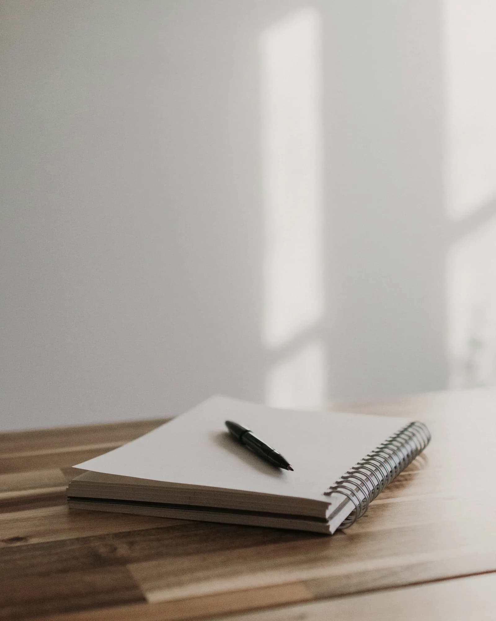 A checklist and pen on a desk in minimal daylight.