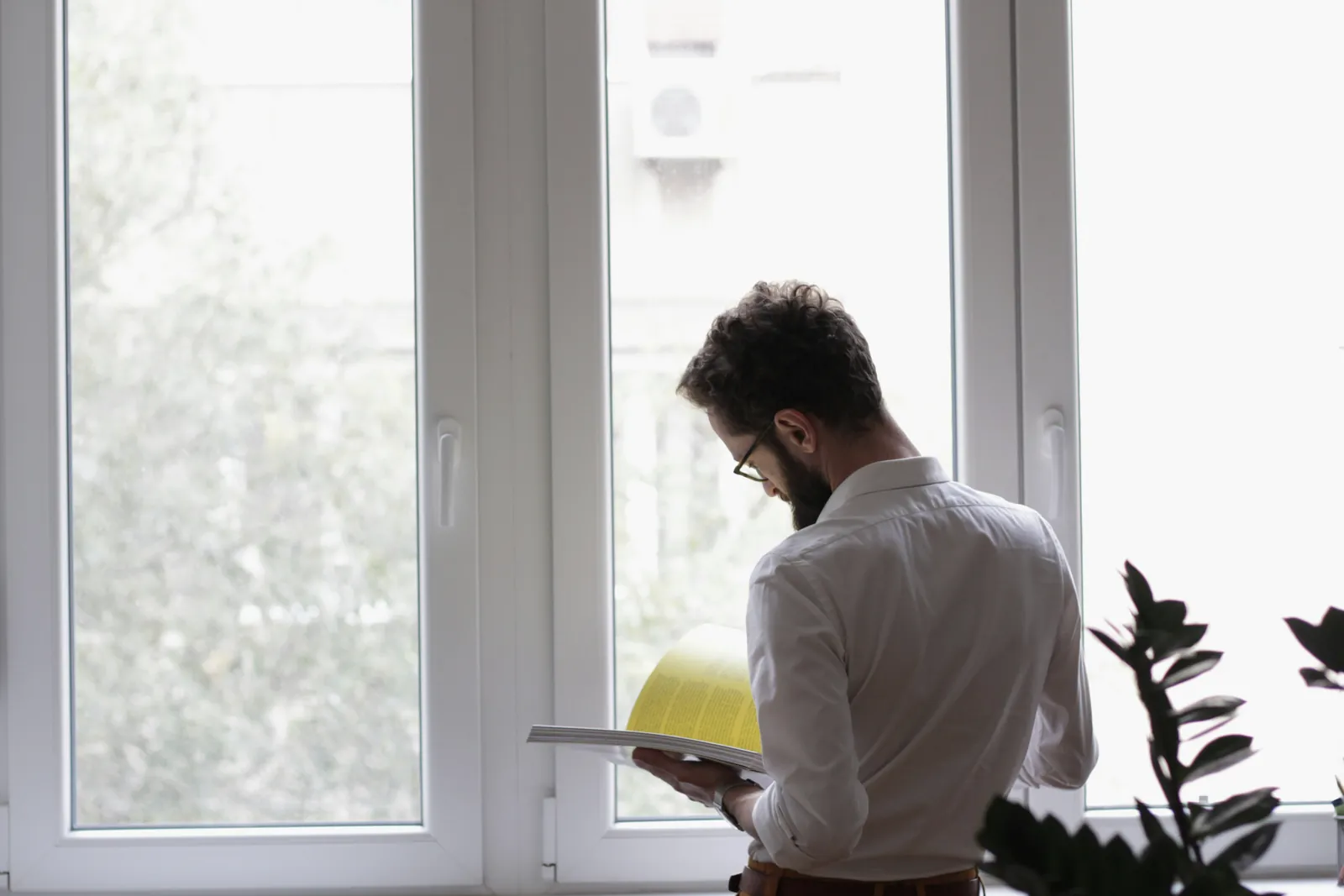 An engineering lead at a standing desk with two monitors, back to camera.